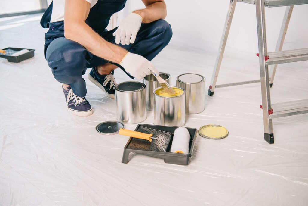 cropped-view-of-painter-taking-yellow-paint-from-c-2024-11-18-19-18-16-utc